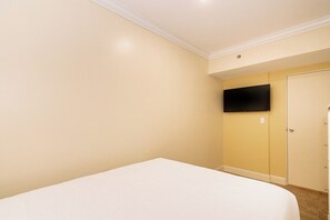 A bedroom with a bed, a wardrobe, and a flat-screen TV mounted on the wall. - Divi Village 3BR Condo w/ Golf View, near Beaches (Oranjestad)