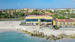 A beachfront hotel with a pool, beach chairs, and a view of the ocean. - Divi Aruba: 3BR Oasis w Free Parking near Beaches (Oranjestad)
