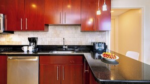 A modern kitchen with dark wooden cabinets, a stainless steel dishwasher, a coffee maker, and a toaster. - Divi Aruba: 3BR Oasis w Free Parking near Beaches (Oranjestad)