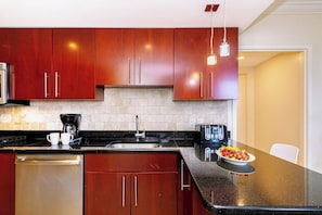 A modern kitchen with dark wooden cabinets, a stainless steel dishwasher, a coffee maker, and a toaster. - Divi Aruba: 3BR Oasis w Free Parking near Beaches (Oranjestad)