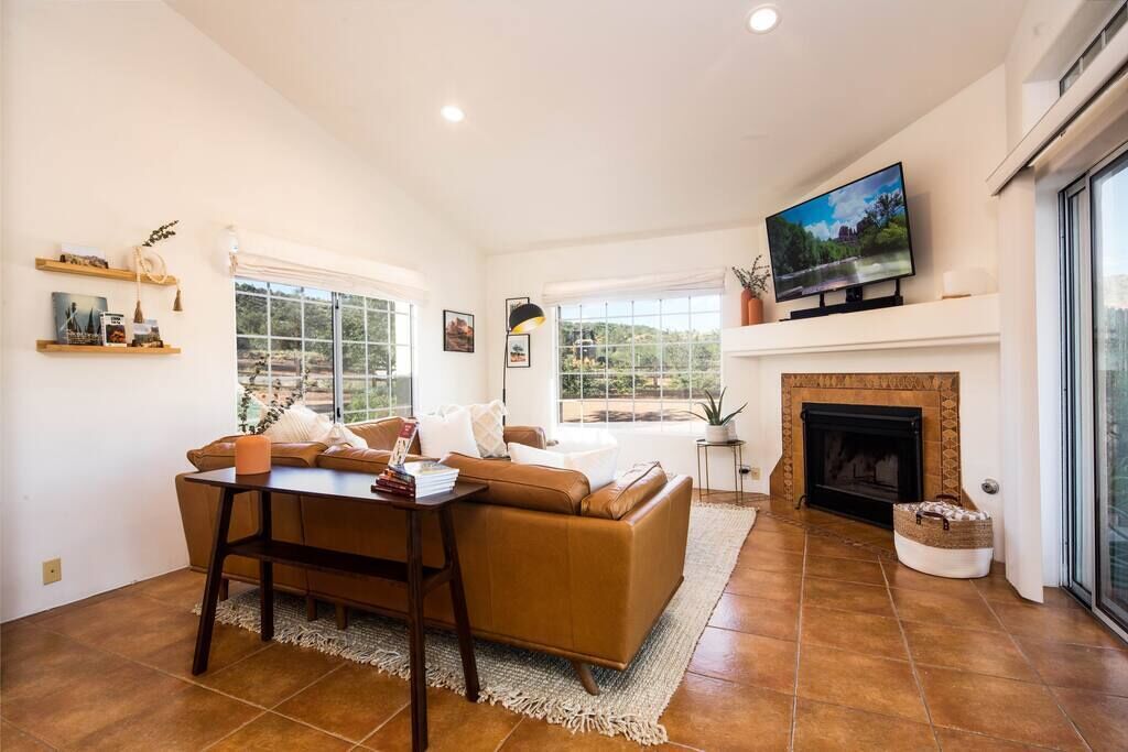 A living room with a sofa, a coffee table, a fireplace, and a television.