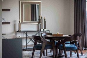 A dining area with a round table, dark wooden chairs, and a large mirror above the table. - Spacious Family Home Overlooking Little Traverse Bay (Harbor Springs)