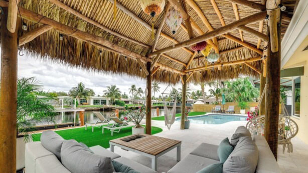 A covered outdoor seating area with a pool in the background. - 1 Mi to Pompano Beach: Vacation Rental w/ Pool! (Pompano Beach)