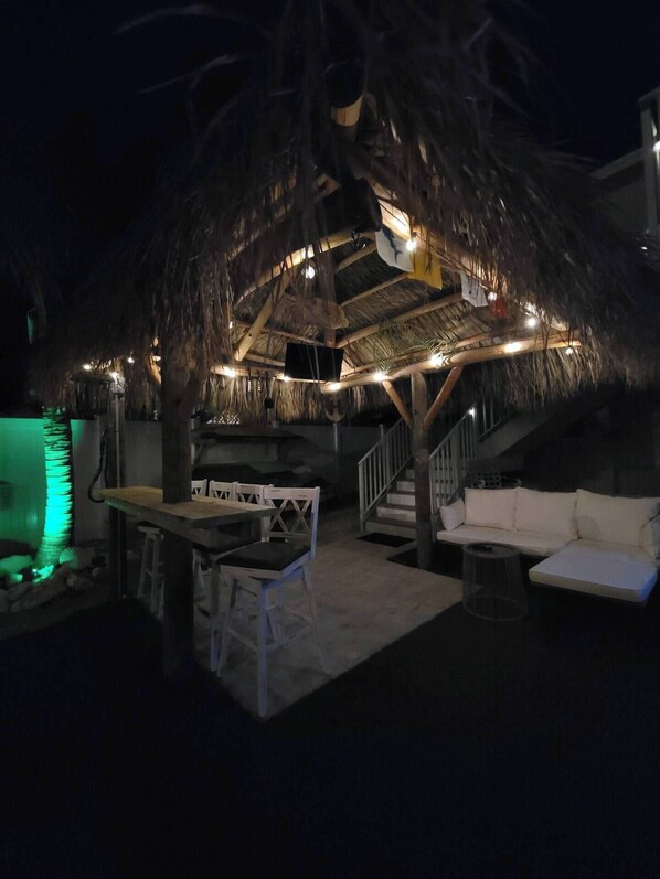 Relax in the shaded lounge area with a sofa, table, and chairs.