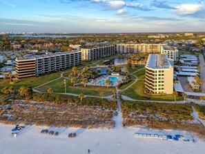 A hotel with multiple buildings, a swimming pool, and a beach area.