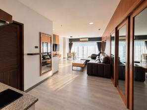 A modern hotel room with a living area, a dining space, and a large sliding glass door to a balcony. - Condo Express View Talay 6 (Pattaya)