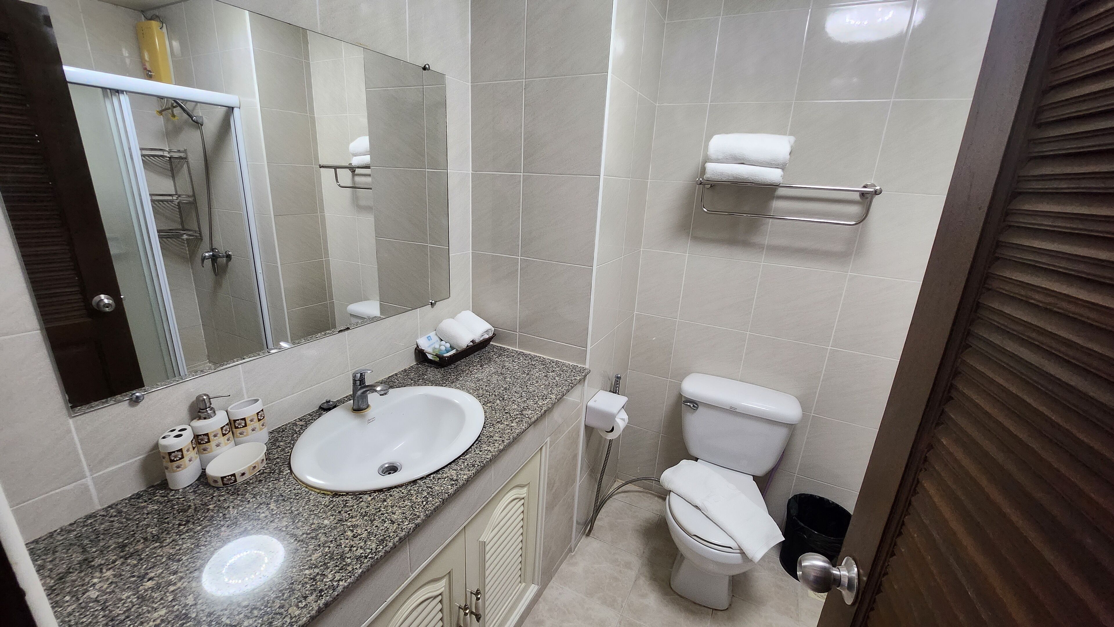 A bathroom with a sink, toilet, and towel rack.