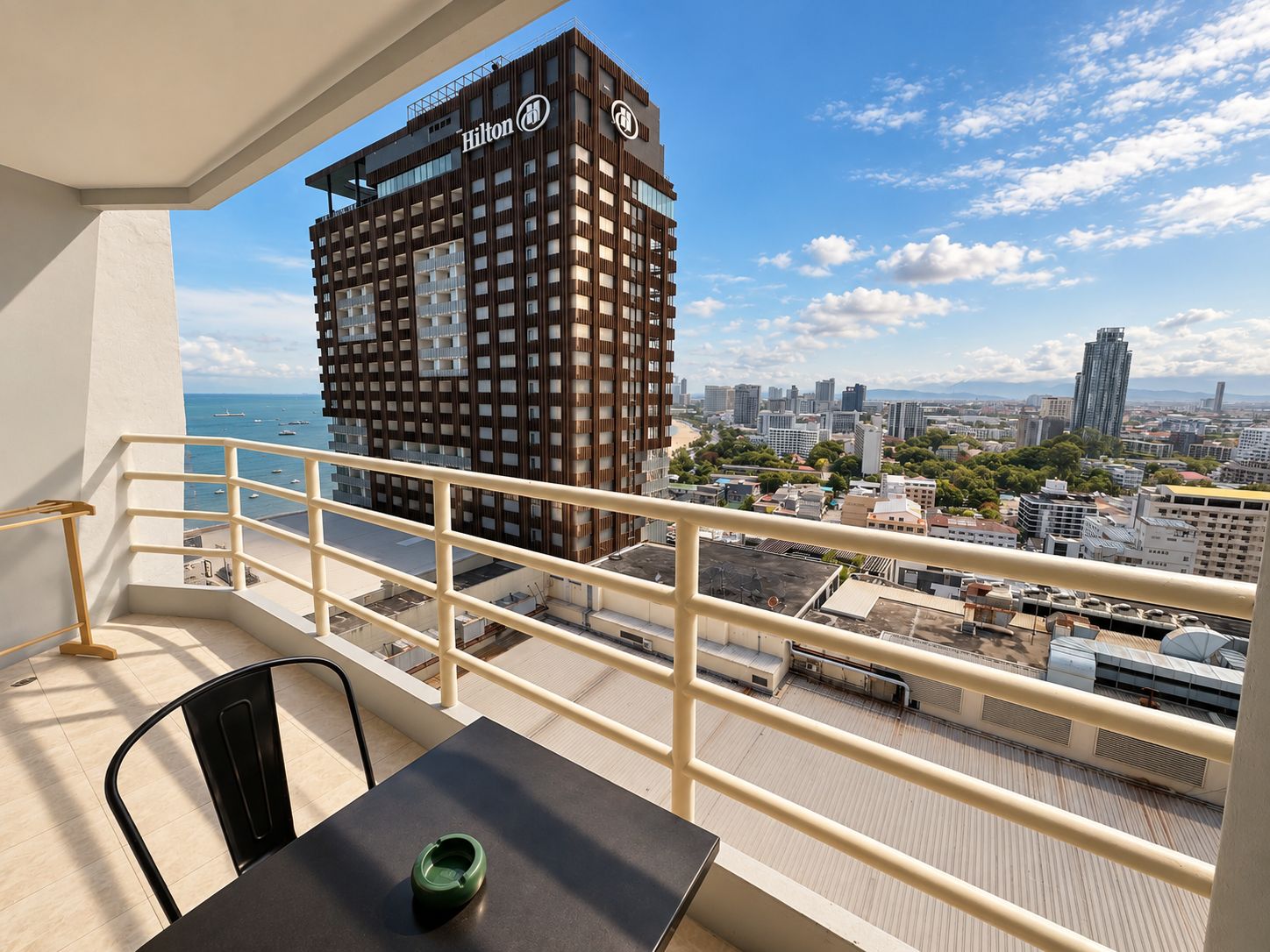 Un balcon avec vue sur un hôtel Hilton et sur le paysage urbain.