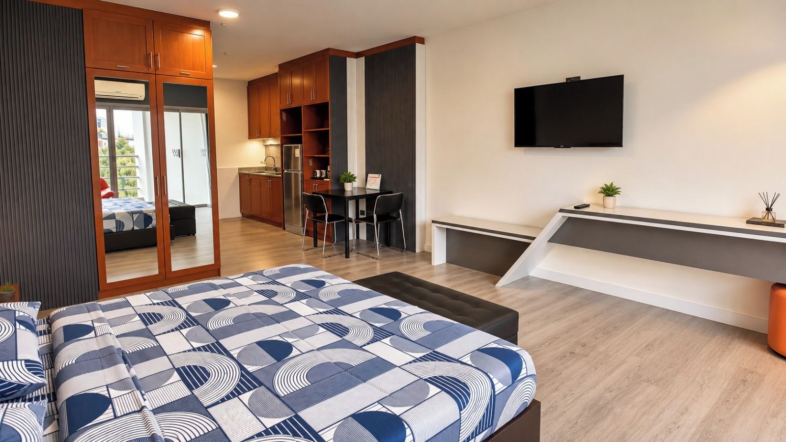A modern hotel room with a bed, a desk, a TV, and a balcony.
