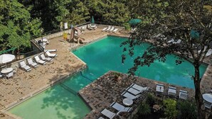 A pool area with lounge chairs, a slide, and a small deck.