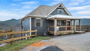 A two-story house with a porch, a garage, and a view of the surrounding landscape. - Haven| DogFriendly | BEST View | Hot Tub | Luxury (Gatlinburg)