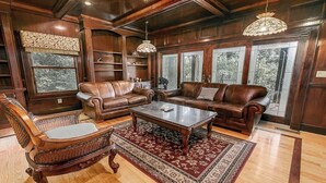 A spacious living room with leather sofas, a wooden coffee table, and a patterned rug.