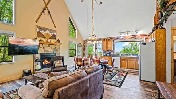 A spacious living room with a fireplace, a large sofa, and a dining area with chairs.