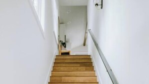 A wooden staircase with a handrail, leading to an upper floor.