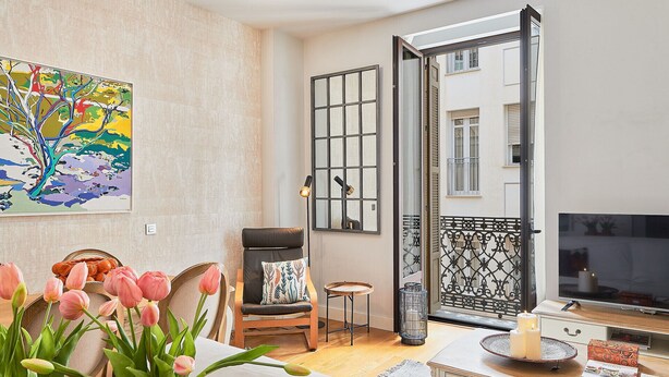 Un salón con sofá, mesa de centro, televisor y un cuadro decorativo en la pared.