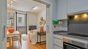 Una cocina moderna con horno empotrado y un comedor con mesa y sillas.