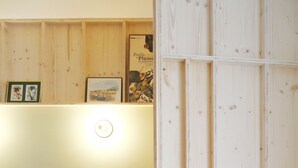 Une chambre à coucher avec un lit, des oreillers, une table de chevet et un mur recouvert de panneaux en bois.