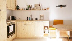 Une cuisine avec des meubles de rangement en bois, un évier, une cuisinière et une table à manger.