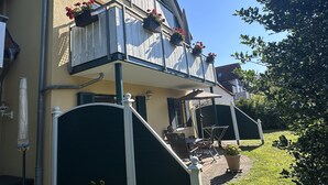 A two-story building with a balcony, outdoor seating, and flower boxes. - Right next to the nature reserve! Great for dogs and nature lovers (Prerow)