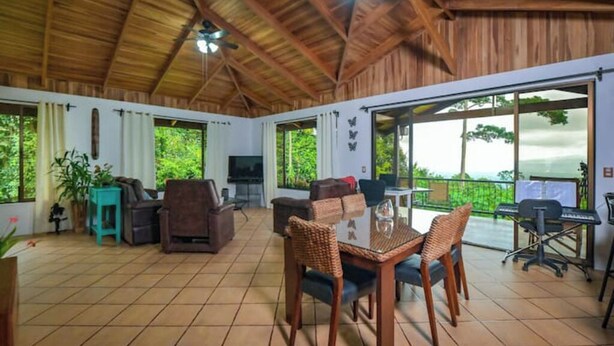 A spacious patio with a dining area, seating, and a TV. - Casa Bromelia, 30 minutes from La Fortuna (La Tigra)
