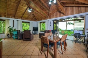 A spacious patio with a dining area, seating, and a TV.