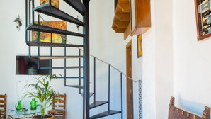 A staircase with a metal railing, a wooden chair, a potted plant, and a table with a green teapot. - Cubo's Finca La Curva High Privacy / Private pool / Views (Pizarra)