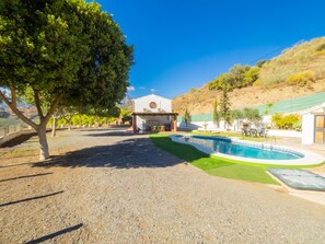 A pool area with a building in the background, surrounded by trees and a hilly landscape. - Cubo's Finca La Curva High Privacy / Private pool / Views (Pizarra)