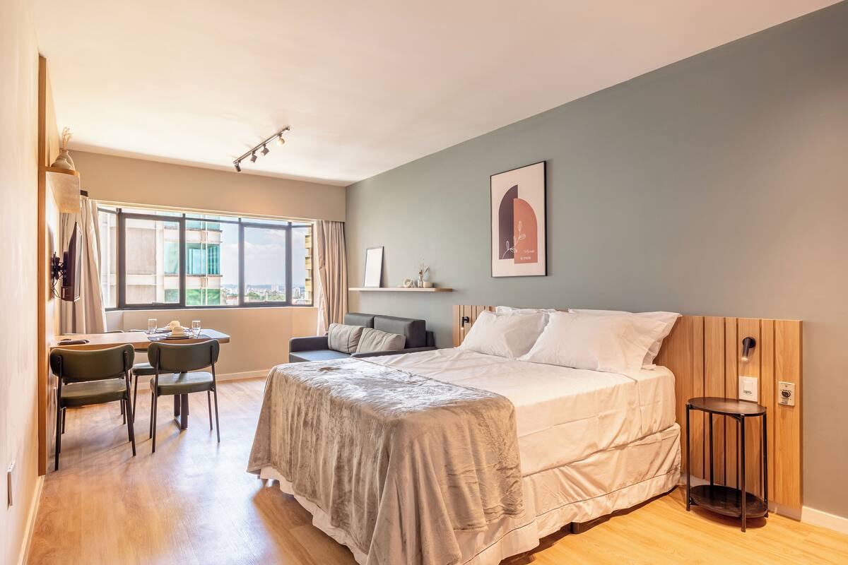 Un dormitorio con cama, escritorio y silla.