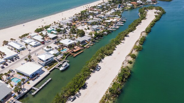 An aerial view of a coastal resort with multiple buildings, a marina, and a beach. - Private 2 BR steps from beach on Casey Key (Nokomis)