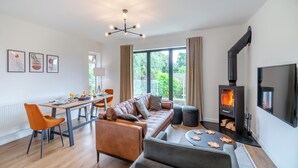 A modern living room with a sofa, a dining table, and a fireplace. - 3 bedroom accommodation in Summerbridge, near Pateley Bridge (Summerbridge, near Pateley Bridge)