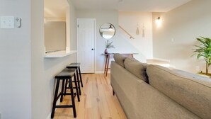 A modern living room with a sofa, a dining area with a table and chairs, and a kitchen visible in the background. - 2 Mi to Old Town: Home w/ Pool Access & Patio (Scottsdale)