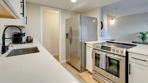 A modern kitchen with a stainless steel refrigerator, a built-in oven, and a dishwasher. - 2 Mi to Old Town: Home w/ Pool Access & Patio (Scottsdale)
