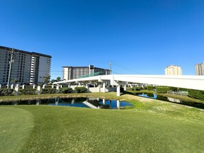 Un edificio moderno con una tettoia, un piccolo stagno e vegetazione circostante.