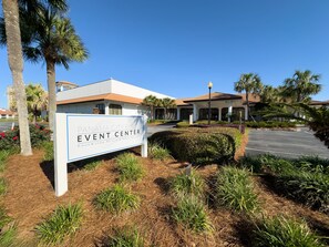 Segnaletica per il Panama City Beach Event Center, con un parcheggio e palme sullo sfondo.