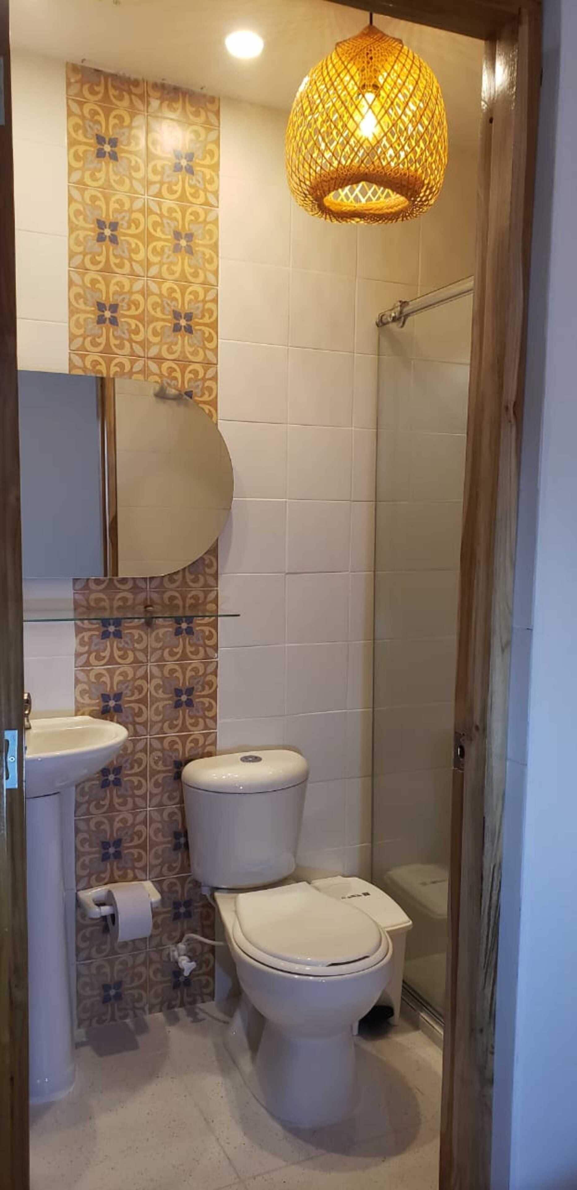 A bathroom with a toilet, sink, and shower.