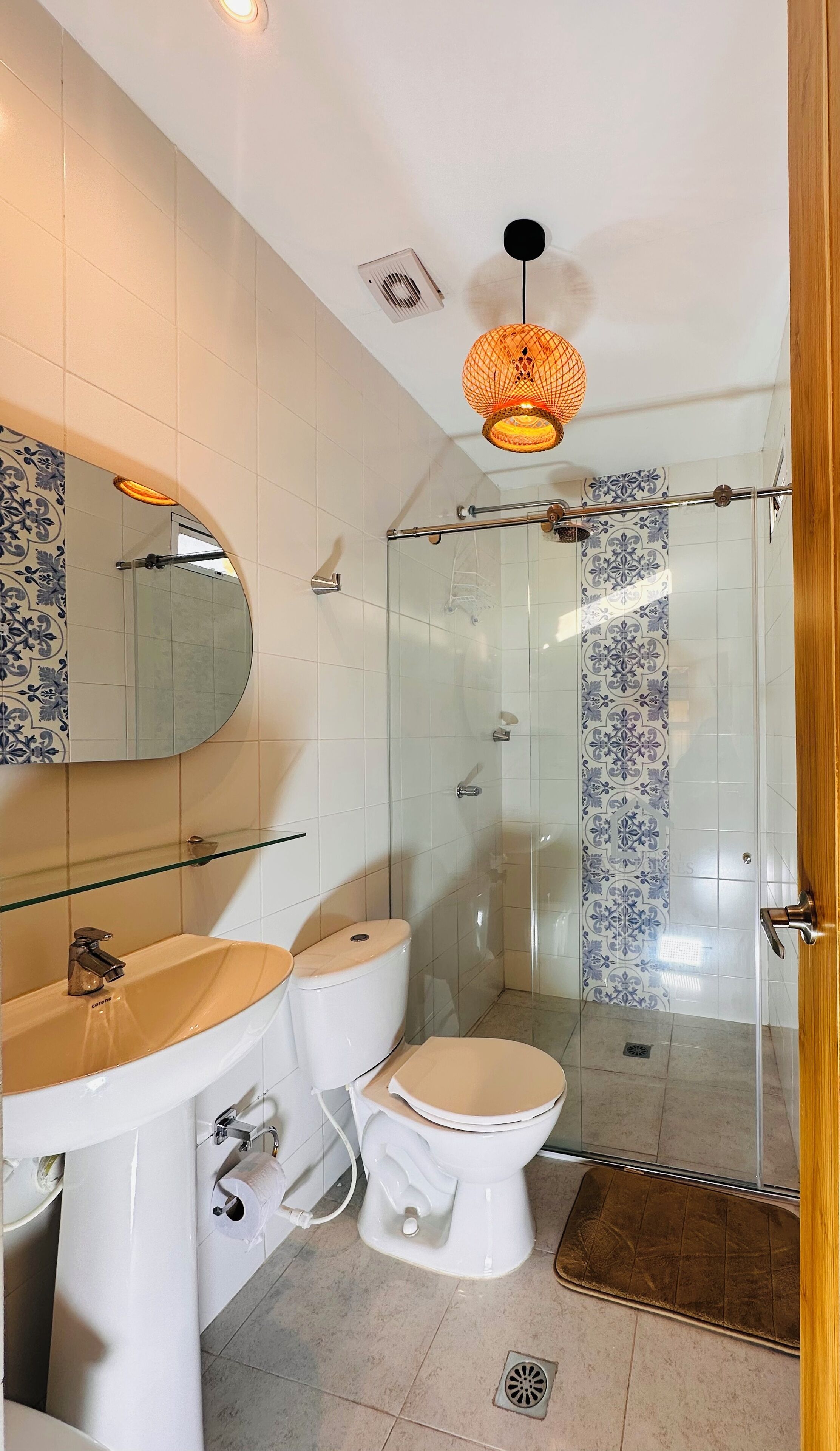 Ein Badezimmer mit Duschkabine aus Glas, einem weißen Waschbecken und einer Toilette.