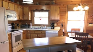 Una cucina con mobili in legno, un frigorifero, un fornello e un lavello.