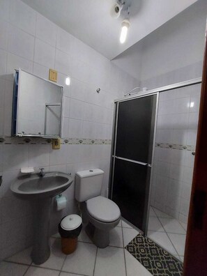 Un baño con lavamanos, inodoro y ducha.