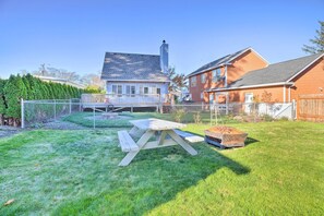 Un patio trasero con una mesa de picnic de madera y una terraza de madera.