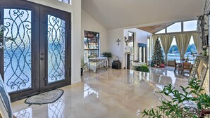 Un vaste espace de vie doté d’un plancher ciré, d’un sapin de Noël et d’une pancarte indiquant « BIENVENUE ».