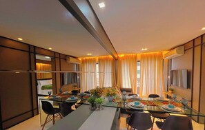 Un comedor moderno con una mesa de vidrio, sillas y un sofá.