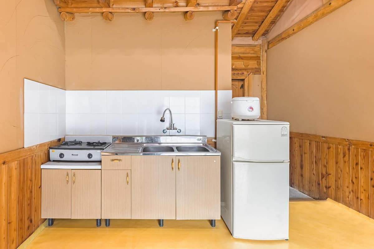 Eine kleine Küche mit Herd, Spüle und Kühlschrank.