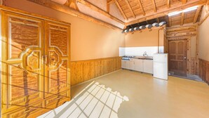 A kitchen with wooden cabinets, a stove, and a refrigerator. - Gapyeong Dolgungpensyeon&kaempingjang (Gapyeong)