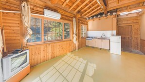 A wooden cabin with a kitchen area, including a refrigerator, stove, and sink. - Gapyeong Dolgungpensyeon&kaempingjang (Gapyeong)