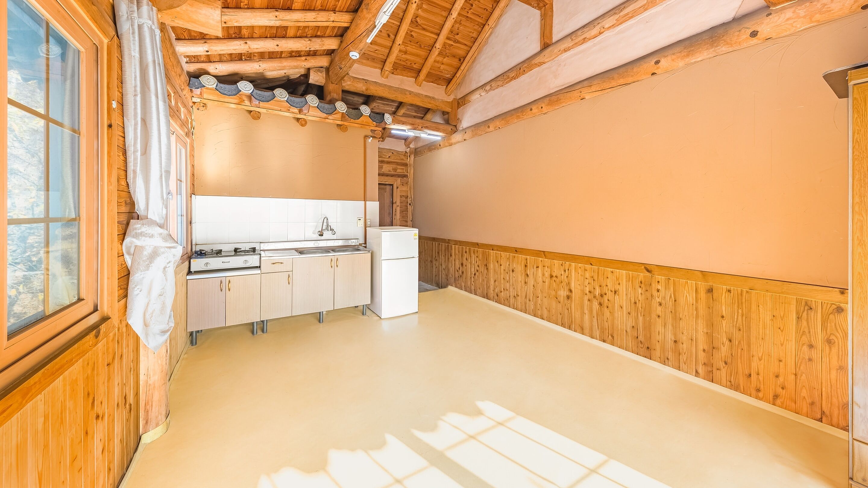 A kitchen with wooden cabinets, a sink, and a refrigerator.