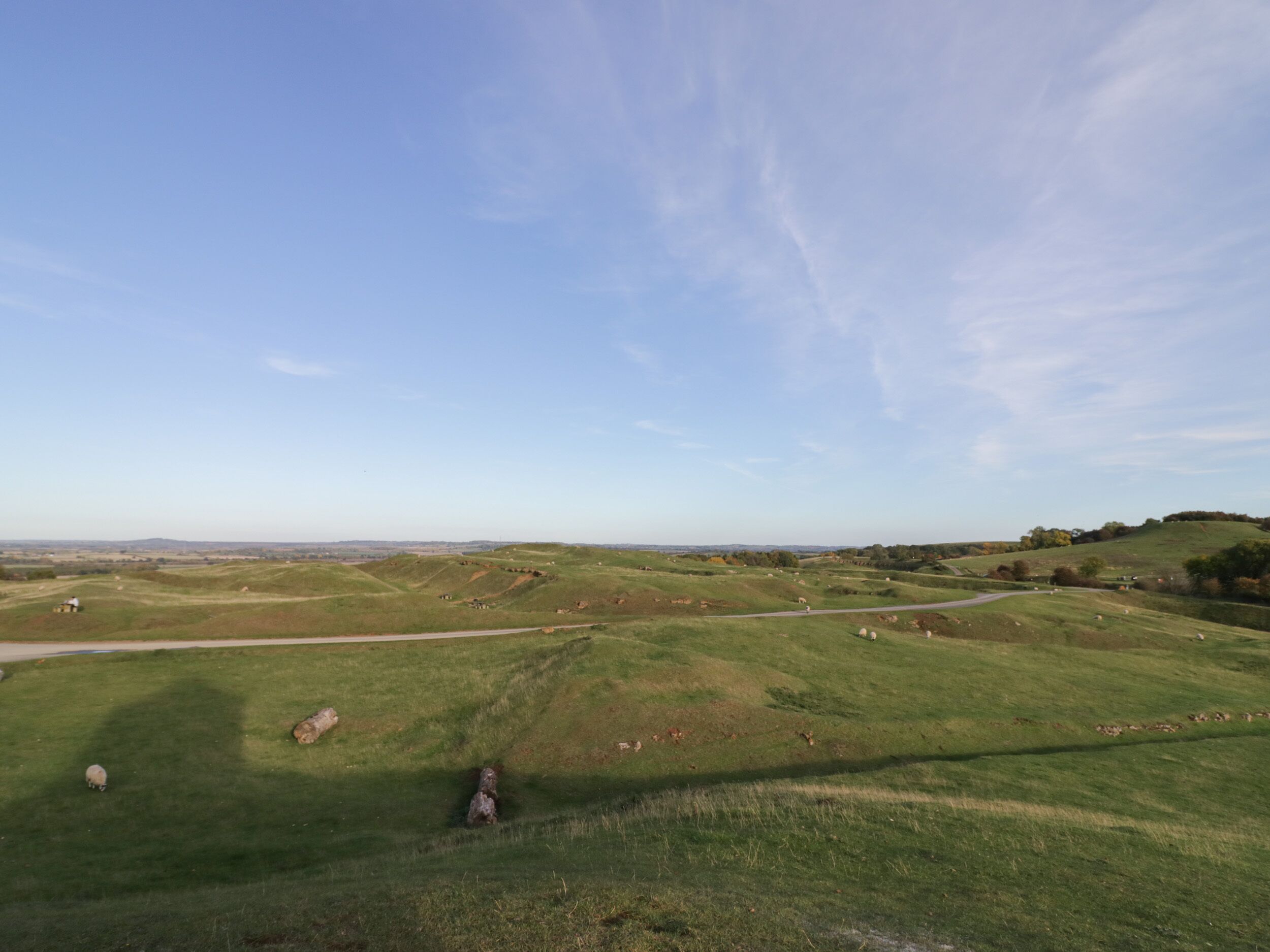 A wide, open field with rolling hills and a clear sky.