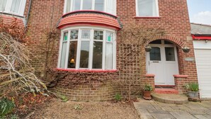 A two-story brick house with a bay window and a front door. - Clover Leaf (Guisborough)