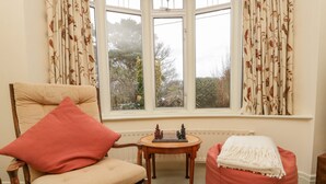A cozy room with a wooden chair, a red cushion, a small table with a chess set, and a red bean bag chair. - Clover Leaf (Guisborough)