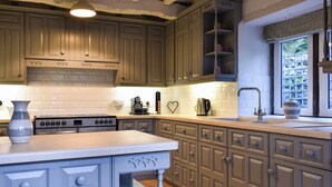A kitchen with wooden cabinets, a stove, and a sink.