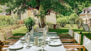 A table set for six with a green checkered tablecloth, white napkins, and clear glassware, surrounded by wooden chairs. - Gorgeous home in Sarrazac (Sarrazac)